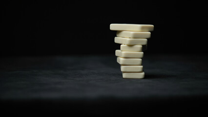 Photo of placing pyramid with domino elements on black