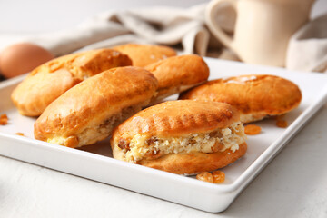 Plate of tasty sochniki with cottage cheese on white background, closeup