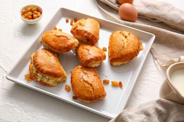 Plate of tasty sochniki with cottage cheese on white background