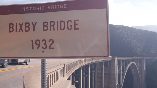 Bixby creek bridge road sign, pacific coast highway 1 landmark. Historic scenic Cabrillo road. Arch architecture. Coastal road trip, journey or travel by ocean. Canyon in foggy weather. California USA