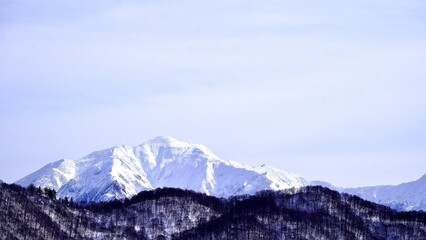 Fototapeta na wymiar 薄曇りの日の新潟県湯沢町から見た冬の谷川岳と谷川連峰の望遠写真