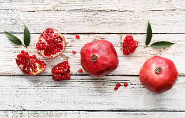 Ripe delicious pomegranate on light wooden background