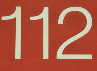 112, emergency number on red background