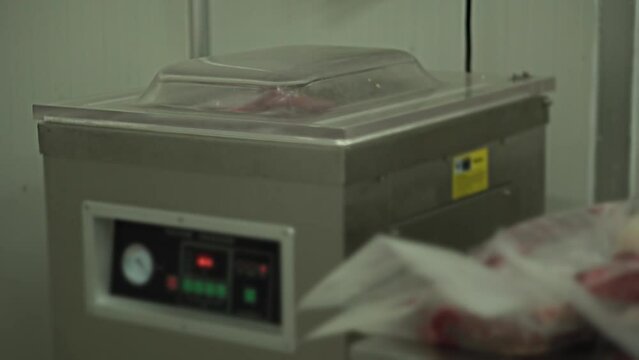 Close-up video Meat industry, butcher cut raw meat with a knife at table in the slaughterhouse, Wagyu Beef,Packing , Vacuum Packing Machine, Digital scale.

