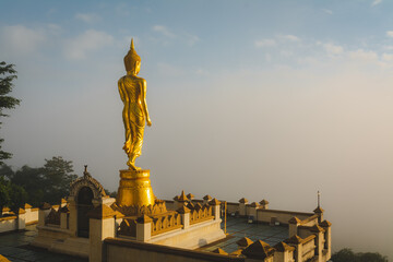 Golden Buddha statue in the morning at Wat Phra That Khao Noi, or Phrathat Khao Noi temple, is the top attraction with a fantastic view of Nan province, Thailand