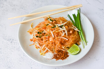 Thai food fried noodle Thai style with prawns bean sprout and garnish peanuts chili powder sugar lemon lime, Stir-fry noodle Pad Thai on plate served on the dining table food - top view