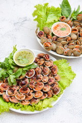 Peeled cockles with seafood sauce and vegetable salad lettuce on white plate background, Fresh raw shellfish blood cockle ocean gourmet seafood in the restaurant, sea shells food