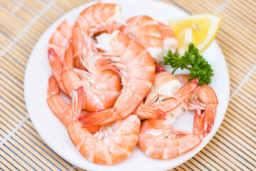 fresh shrimps served on white plate with parsley lemon , boiled peeled shrimp prawns cooked in the seafood restaurant