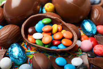 Fototapeta na wymiar Chocolate Easter eggs with candies and sprinkles, closeup