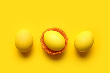 Yellow painted Easter eggs on color background