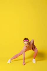 Obraz na płótnie Canvas Workout. Athletic Young Woman Doing Exercises Over Yellow Studio Background. Copy Space