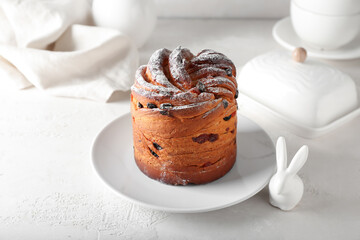 Plate with delicious Easter cake on light background