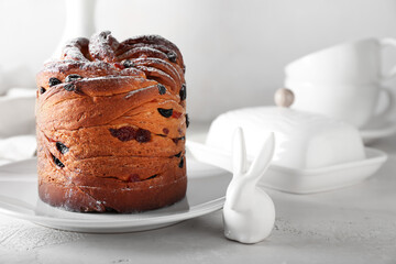 Plate with delicious Easter cake on light background