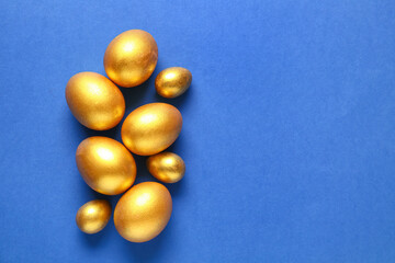 Golden painted Easter eggs on blue background