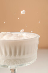 Milk pours into a beautiful crystal glass and splashes around.