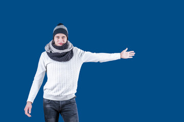 A white man with a hat and scarf extended his hand to the side