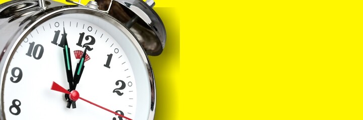 Alarm clock on yellow background. Christmas and Happy new year concept.