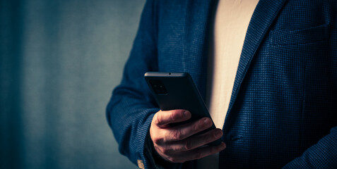 businessman holds a smartphone in his hand, the concept of online communication