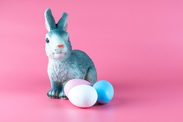 rabbit and painted multicolored easter eggs on pink background