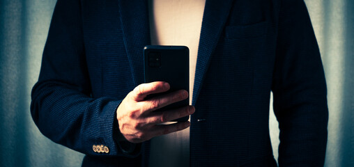 businessman holds a smartphone in his hand, the concept of online communication