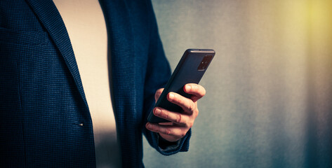 businessman holds a smartphone in his hand, the concept of online communication