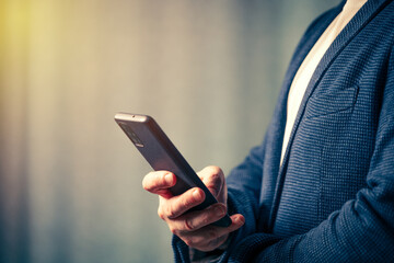 businessman holds a smartphone in his hand, the concept of online communication