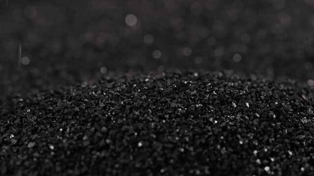 pouring black coconut charcoal close-up slo-mo, activated carbon small fraction