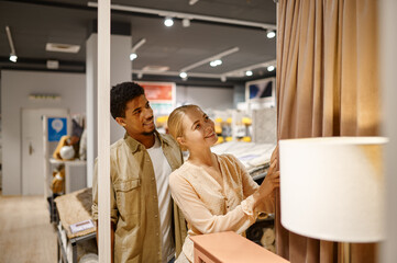 Happy couple choosing curtains making shop purchases