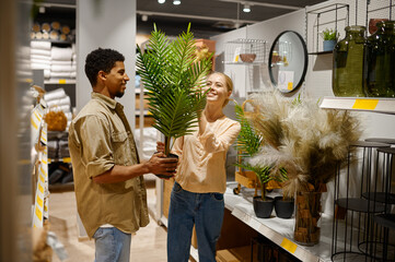 Happy couple buying decorative potted palm tree