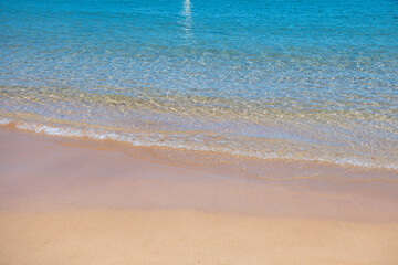 Fototapeta na wymiar Calm sea beach background. Summer tropical beach with sand. Ocean water. Natural seascape.