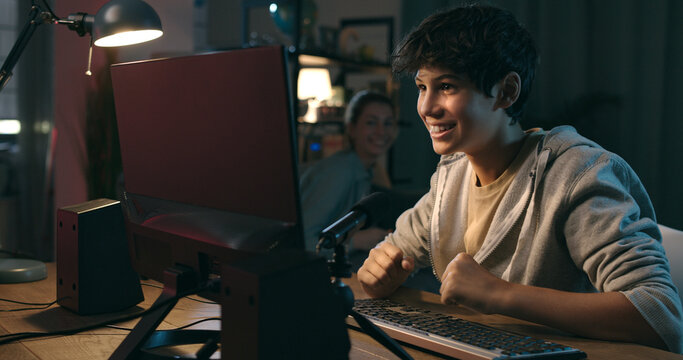 Boy playing online video games at home