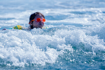 Happy child girl playing in the sea. Kid having fun outdoors. Summer vacation and healthy lifestyle concept. Horizontal image.