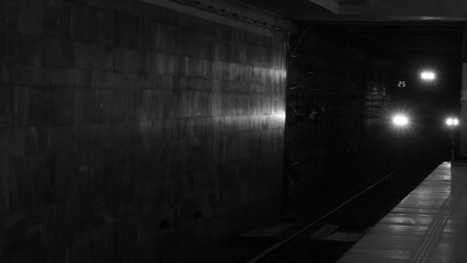 Black and white photo. Moving underground train. The arrival subway train at the station. City without traffic jams.