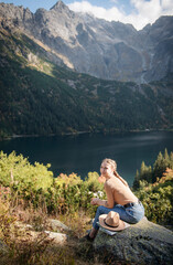 Young woman on a hiking trip sitting on a rock