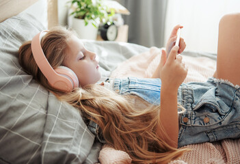 Little girl with mobile phone listening to music