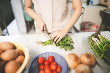 Woman hand using knife prepared cutting coriander at home.