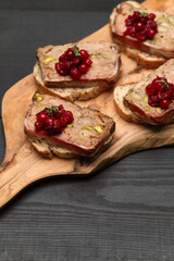 Sliced Traditional French terrine covered with bacon on dark wooden background