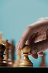 Player moving a pawn on the chessboard