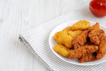 Homemade Nuggets and Chicken Tenders with Sweet and Sour Sauce on a white wooden background, side view. Space for text.