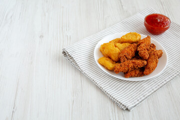 Homemade Nuggets and Chicken Tenders with Sweet and Sour Sauce on a white wooden background, side view. Space for text.