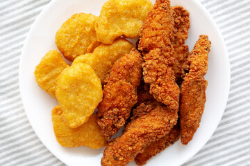 Homemade Nuggets and Chicken Tenders on a Plate, top view. Overhead, from above, flat lay.