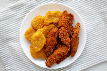 Homemade Nuggets and Chicken Tenders on a Plate, top view. Overhead, from above, flat lay.