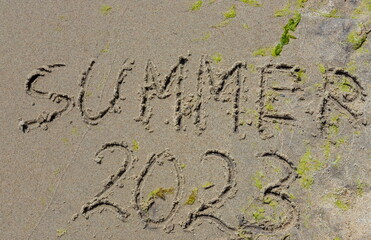 The inscription on the sand Summer symbolizes a summer 2023 vacation at the sea