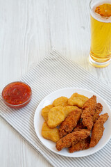 Homemade Nuggets and Chicken Tenders with Sauce and Beer, side view. Copy space.