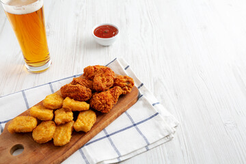 Homemade Crispy Fried Chicken Wings and Nuggets on a rustic wooden board, low angle view. Copy space.