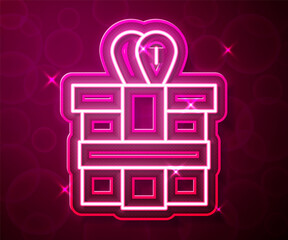 Glowing neon line Gift box icon isolated on red background. Vector