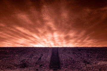 blask zachodzącego słońca na czerwonym niebie w nierealnym obrazie i schody prowadzące w górę