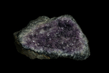 Druse of Amethyst mineral, a violet quartz stone on black background.