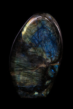 Polished labradorite mineral, decorative stone on black background.