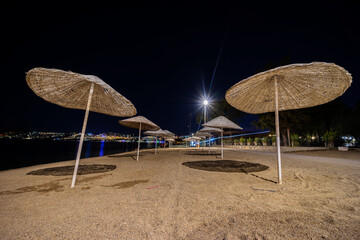 Night landscape with a view of the beach wicker umbrellas. - 484128307